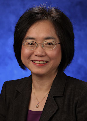 A portrait photograph of Dr. Shou Ling Leong smiling in front of a blue background.
