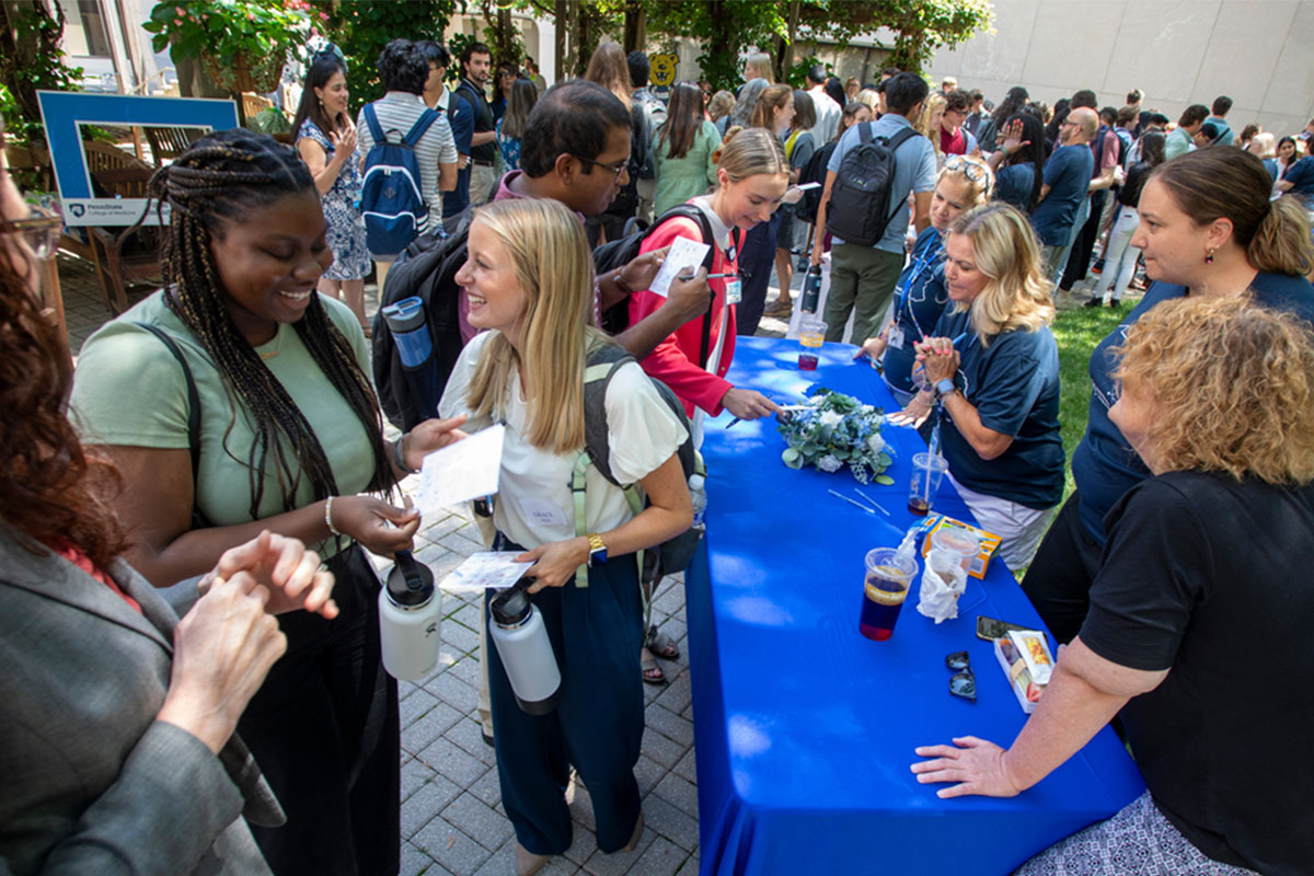 Adesuwa Emovon, left, and Grace Petryk, second from left, first year medical students from Penn State College of Medicine students, joined their classmates during the orientation garden party on Tuesday, July 11, 2023.