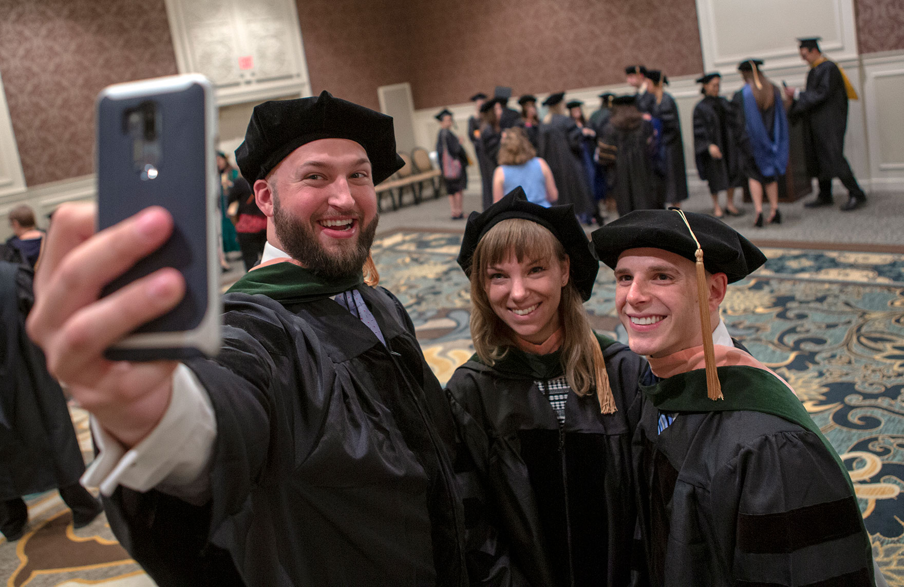 Penn State College of Medicine's MD-MPH program graduated three students in May 2019. They are pictured taking a selfie at Commencement.