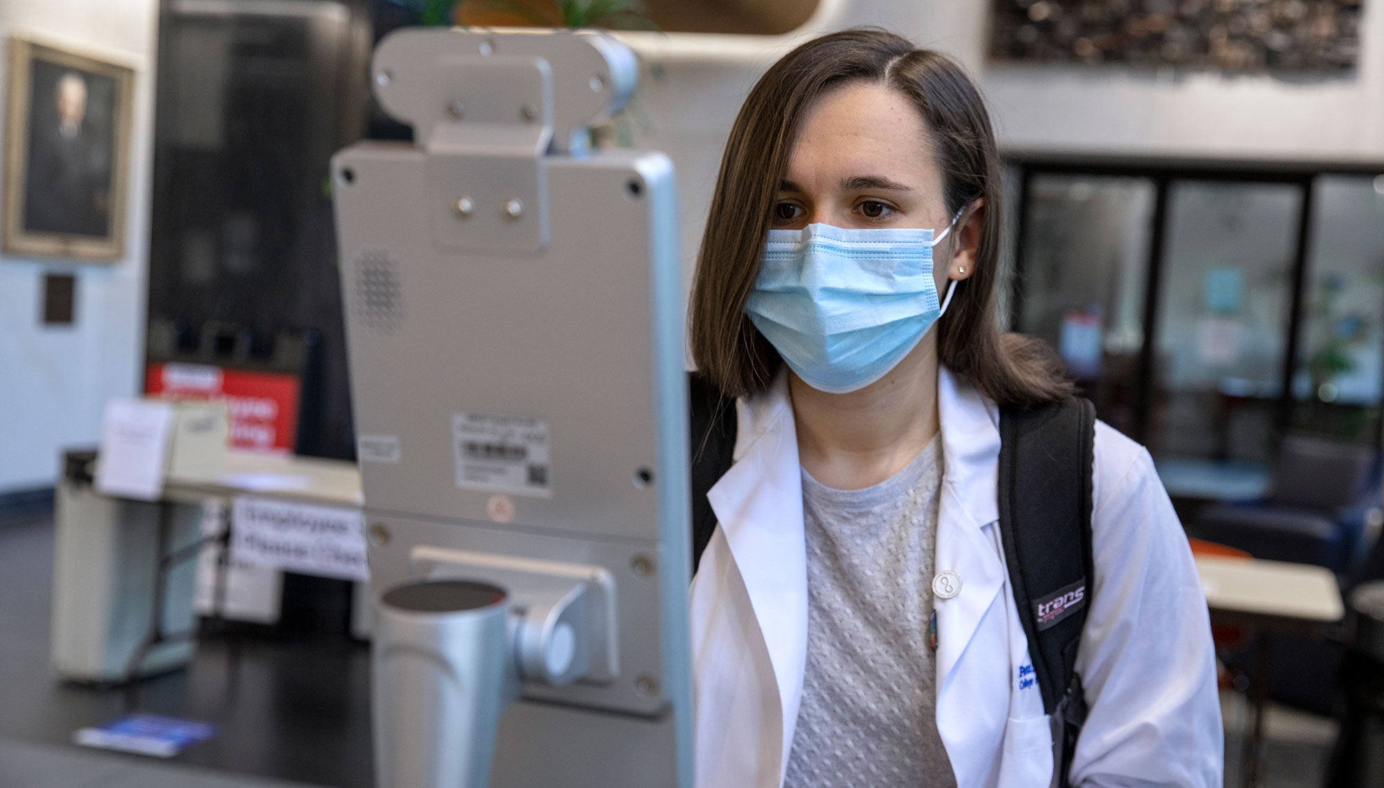 A Penn State College of Medicine student uses an automated, touchless temperature scanner before entering the building due to COVID-19.