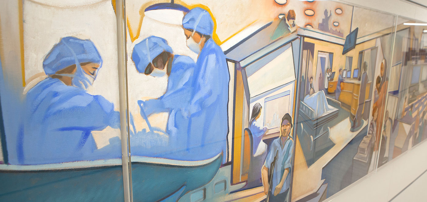A painting is seen in the hallway of Penn State College of Medicine. It depicts scenes from campus, including surgeons at work, a sheet-draped person in a hospital bed and more, in soft neutral tones.