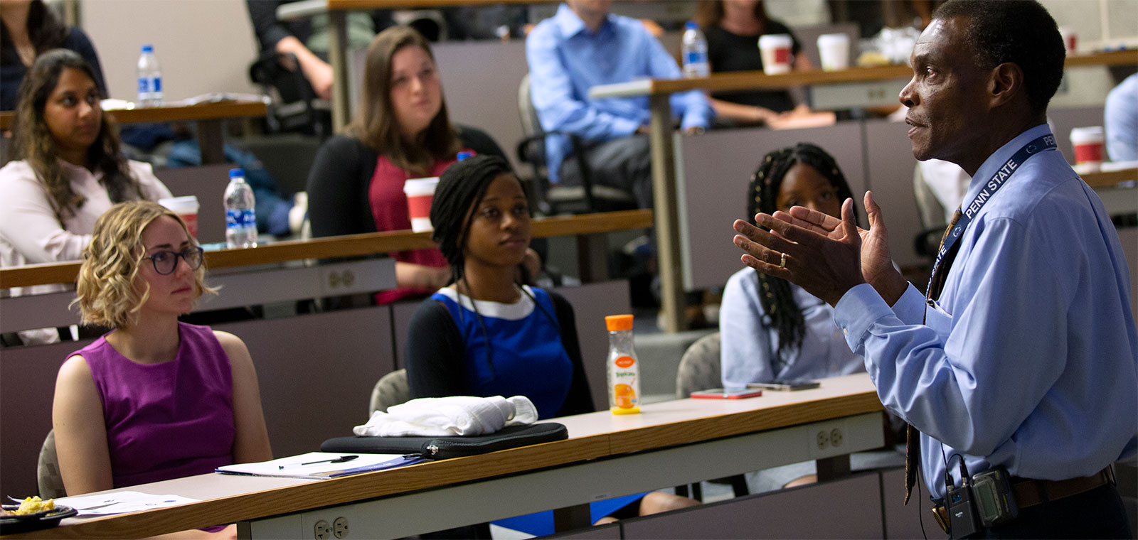 Dr. Dwight Davis addresses students at the 2019 MD student orientation in Hershey, Pa. He is gesturing with his hands and students are seen sitting in rows in a lecture hall in front of him.