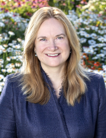 A head-and-shoulders professional photo of Dr. April Armstrong in a medical coat and dress clothing on a professional photo background.