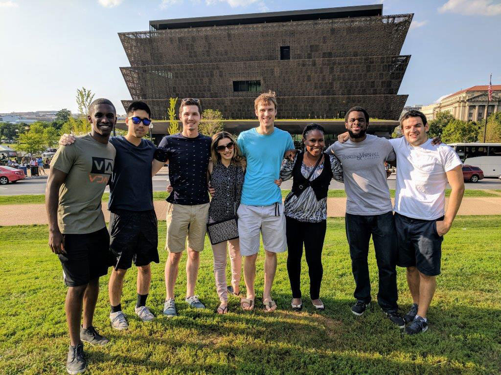 Student leaders Brandon Williams, Leon Lin, Robert Fort, Pardis Pooshpas, David Booth, Felicia Cooper, Nd Ekpa and Andrew Feldman are pictured on a group trip to the National Museum of African American History in Washington, D.C., in 2017. The students were representatives or leaders for Student National Medical Association, Military Medical Interest Group, PSUCOM Pride, American Medical Women Association, LAMSA and Jewish Union of Medical Professionals. The students are pictured standing on a lawn with the museum visible in the background. The photo was taken in 2017.