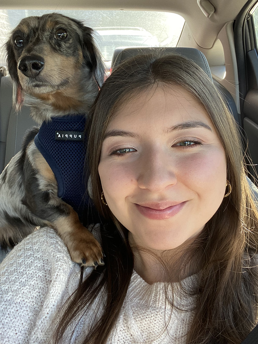 Selfie in a car of Juliana Restrepo and her puppy, Lalo, over her right shoulder