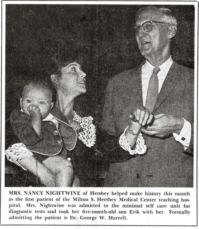  A newspaper clipping shows a photo of Nancy Nightwine, holding a baby, lifting her wrist up to Dr. George Harrell, who had just put a hospital bracelet on her. A caption explains Nightwine became the first patient at Hershey Medical Center.