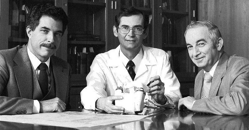Gerson Rosenberg, William S. Pierce, MD, and James H. Donachy sit at a table with a heart-assist pump