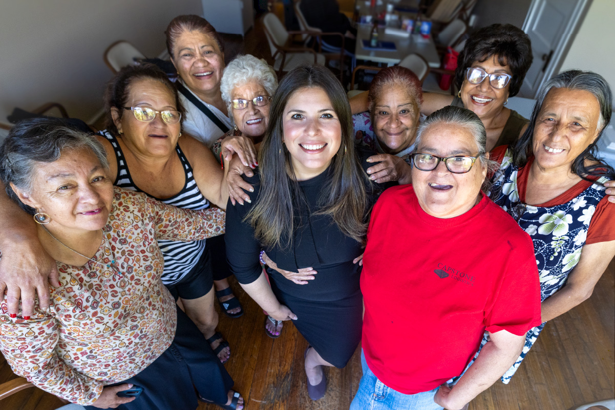 Sol Rodríguez-Colón, in the center, with 8 women all around her, all smiling and looking up toward the camera.