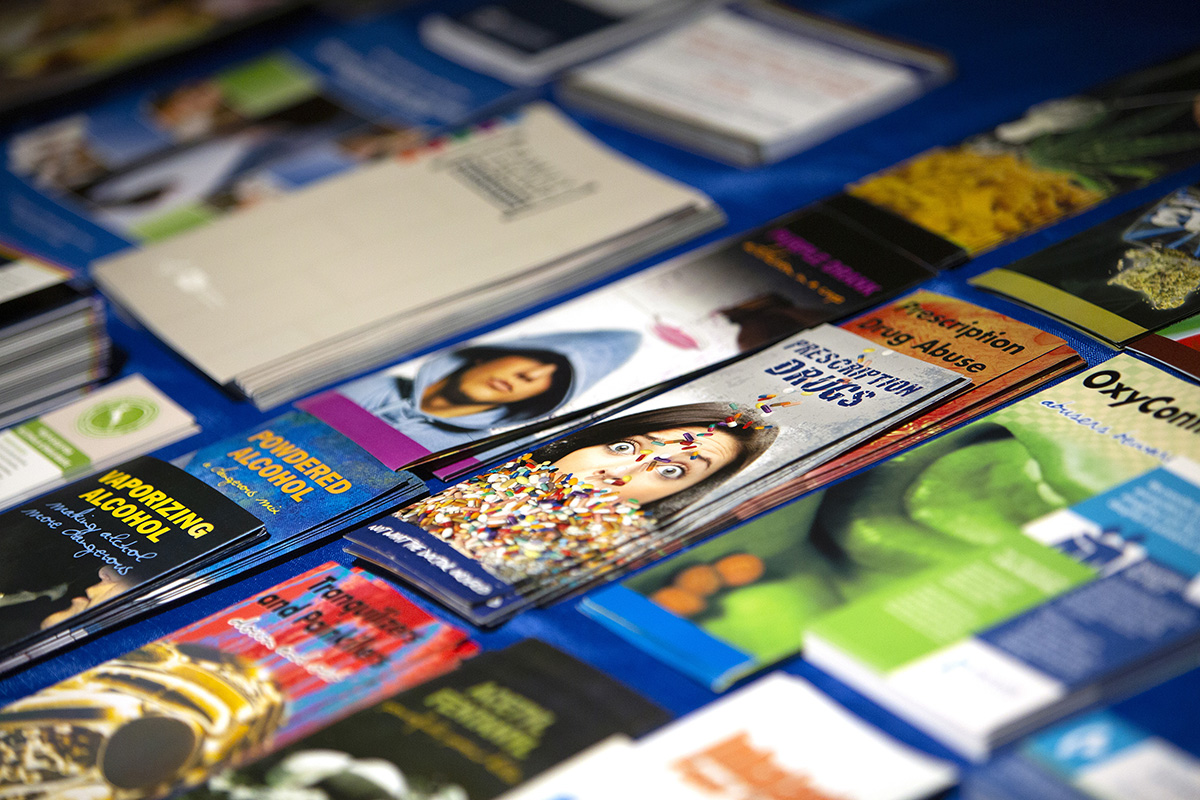 Close up of pamphlets related to drug abuse and alcohol stacked on a table.